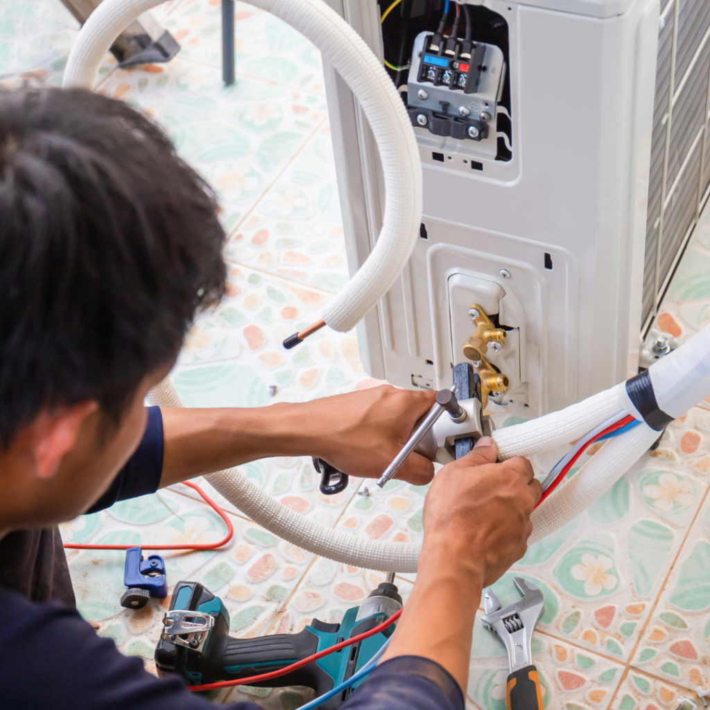 technician doing maintenance on an AC unit