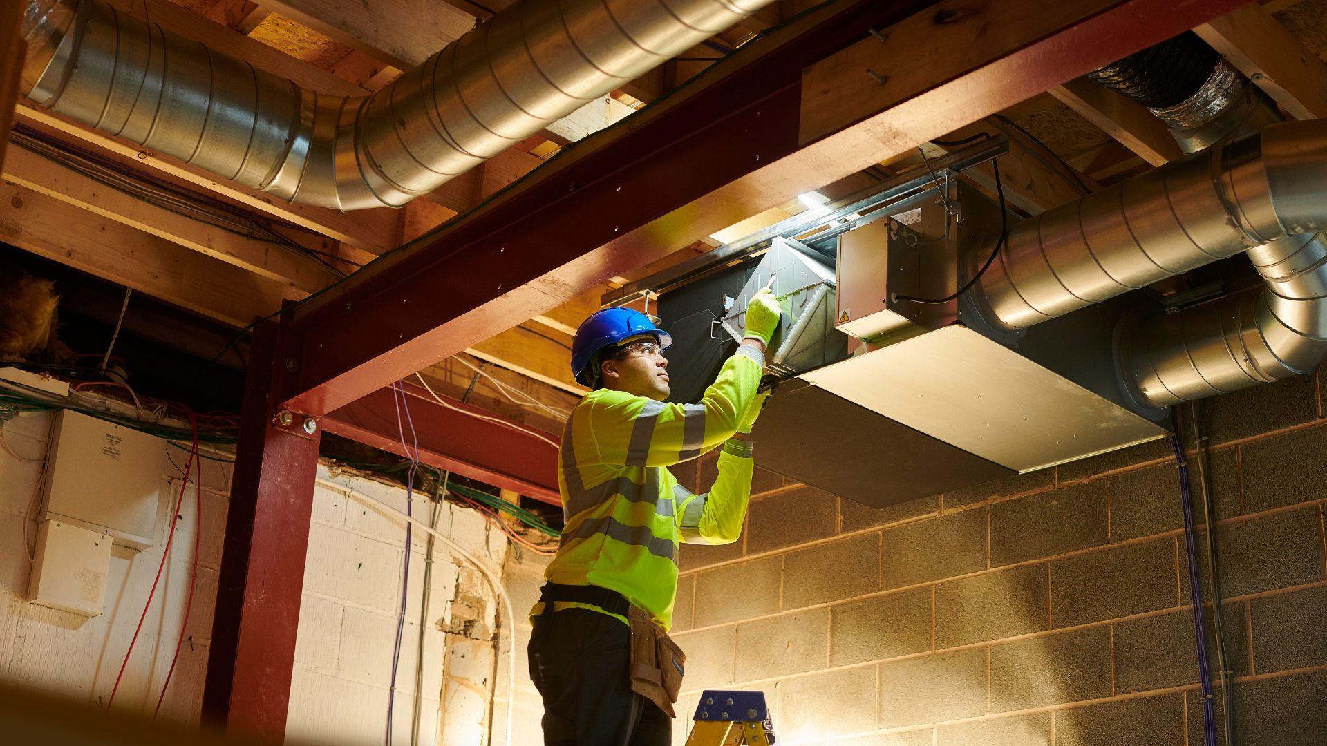 technician working on an air conditioner in the ceiling